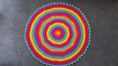 a colorful crocheted doily on a gray surface