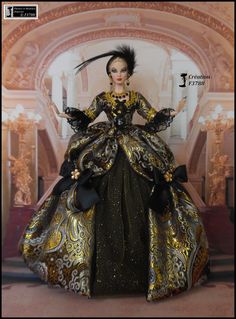 the doll is wearing a black and gold dress with feathers on it's head