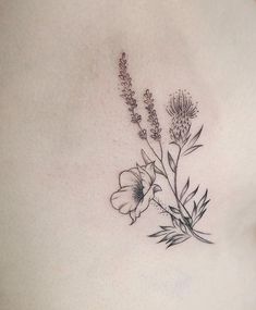 a woman's stomach with flowers and leaves tattoo on her side ribcage