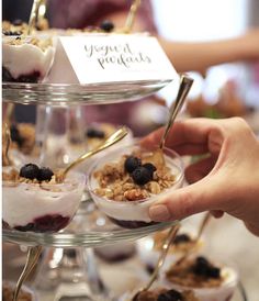 desserts are displayed on three tiered trays with forks and spoons in them