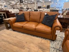 a brown leather couch and chair in a store