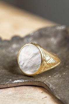 A beautiful signet ring with carvings on the sides made by hand and a mother-of-pearl gemstone in the center. *real images of the ring, taken by us* Mother of Pearl Stone Size: 14x12mm Material: - Sterling Silver 925 - 9K Gold (375) - 14K Gold (585) - 18K Gold (750) *All signet rings are hallmarked on the back for certification* - We offer FREE Worldwide DHL & FedEx Shipping! - Branded DanelianJewelry Gift Box with each order! Carved Mother Of Pearl, Pearl Signet Ring, Oval Antique Signet Ring As Gift, Ceremonial Oval Signet Ring Stamped 14k, Antique Oval Signet Ring For Gift, Heirloom Oval Signet Ring For Ceremonial Occasions, Classic Oval Etched Rings, Classic Etched Oval Rings, Ceremonial Oval Signet Ring With Intaglio