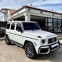 a white suv parked in front of a building