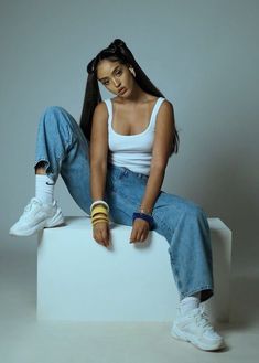 a woman sitting on top of a white box