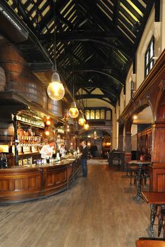 the inside of a restaurant with wooden tables and bar stools in front of it