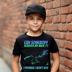 "Bring a burst of color and a lot of laughter into your child's wardrobe with our Unisex Kids' T-Shirt featuring a hand-drawn crazy neon color pattern T-Rex dinosaur. The playful text reads, \"Can somebody scratch my back? I promise I won't bite.\" 🦖🌈 This vibrant and whimsical design will capture the imagination and bring joy to kids of all ages. Who could resist helping out a T-Rex in need? 🎨 The T-shirt showcases a unique and artistic interpretation of the mighty T-Rex, making it an ideal Playful Short Sleeve Tops With Graffiti Print, Black Dinosaur Print Short Sleeve T-shirt, Funny Black T-shirt With Dinosaur Print, Black Short Sleeve T-shirt With Dinosaur Print, Scratch My Back, T Rex Dinosaur, Let The Fun Begin, Whimsical Design, Neon Color