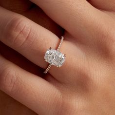 a woman's hand with a diamond ring on top of her finger and an engagement band