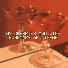 two martini glasses with cherries in them on a table next to a mirror that says, my cherries and wine rosemary and thy