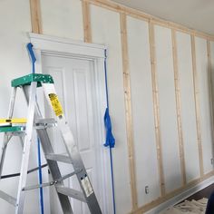 a ladder that is sitting in front of a door with some paint on the walls