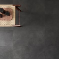 an overhead view of a living room with grey walls and flooring, including a coffee table