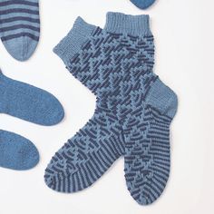 three pairs of socks and one pair of mitts on a white surface with the same pattern