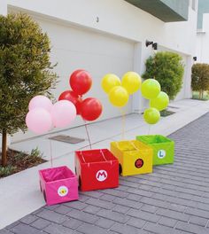 colorful balloons and gift boxes are lined up on the sidewalk