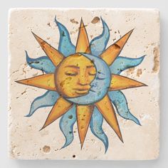 a ceramic tile with a sun and moon painted on it's face in blue and yellow