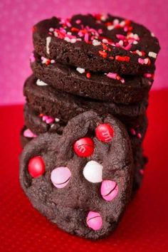 chocolate cookies with pink and white sprinkles are stacked on top of each other