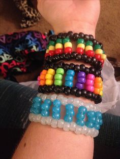 the bracelets are all different colors and designs on each wrist, but one is made out of plastic beads