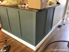 a kitchen island with a box on top of it and tools scattered around the area