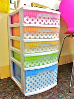 an organized drawer with polka dot drawers on the bottom, and several different colored bins