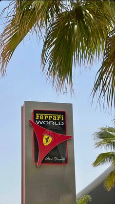 the ferrari world sign is next to some palm trees