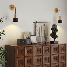 a wooden cabinet with two lamps and a busturine on top next to it