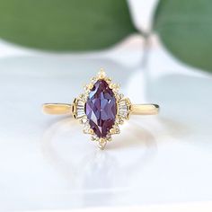 An extraordinary Contemporary Art Deco Marquise Shaped Alexandrite Engagement ring set in 14K gold enveloped in dynamic shapes of diamonds, classy and unique for that special somebody. Pictures don't do this ring justice! Only one ring in 14k Yellow gold is in stock. Check out Instagram page for more photos of this ring in different metal and stone: https://www.instagram.com/p/Bt60PmMFuEJ/ ♦ Main Ring Information ♦ Center Stone: Chatham alexandrite, Marquise Faceted Cut, 10x5mm, Green to purple( Marquise Engagement Ring Gemstone, Elegant Diamond Cluster Ring With Gemstone Accents, Elegant Marquise Ruby Ring Gift, Elegant Marquise Ruby Ring As Gift, Elegant Marquise Gold Ruby Ring, Elegant Wedding Diamond Ring With Gemstone Accents, Exquisite Marquise Diamond Ring, Exquisite Marquise Diamond Ring With Gemstone, Elegant Marquise Ruby Ring With Halo Setting