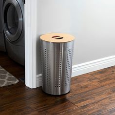 a metal trash can sitting next to a dryer