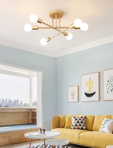 a living room filled with furniture and paintings on the wall next to a large window