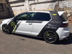 a white car with yellow and black stripes parked in front of a building on the street