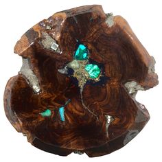 a piece of wood that has some green and blue stones in the middle of it