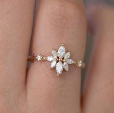 a woman's hand with a diamond ring on top of her finger and an engagement band