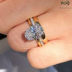 a close up of a person's hand holding an engagement ring with a diamond