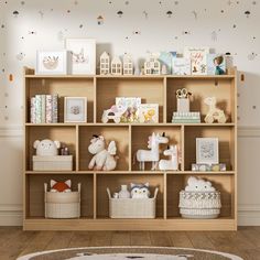 a wooden shelf filled with stuffed animals on top of a hard wood floor next to a white rug