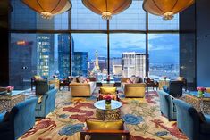 a living room filled with lots of furniture and windows overlooking the city at night time