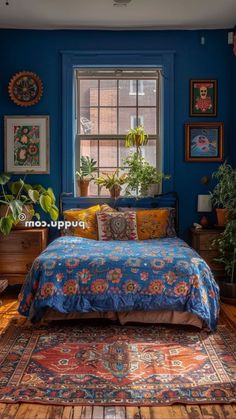 a bedroom with blue walls and rugs, potted plants on the window sill