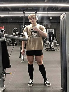 a man standing next to a machine in a gym