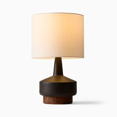 a table lamp with a white shade on it's base and a wooden base