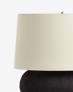 a black lamp with a white shade on it