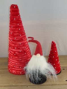 two red and white christmas trees with santa's hats on them, one is made out of paper plates