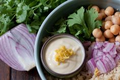 a bowl filled with rice, onions and chickpeas next to cilantro