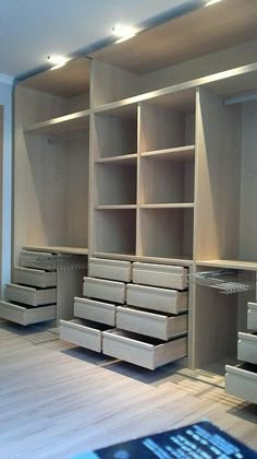 an empty room with wooden shelves and drawers