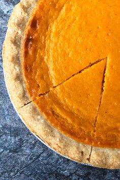 a pumpkin pie with one slice missing from it