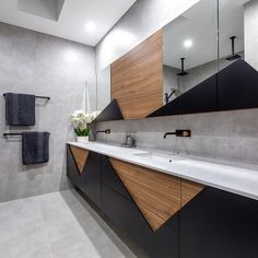 a modern bathroom with black and white fixtures, wood accents, and marble countertops