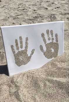 two handprints on a towel in the sand