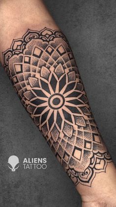 a black and white tattoo design on the arm with an intricate flower in the center