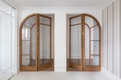 an empty room with double doors and white walls