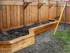 a wooden garden bed sitting in the middle of a yard