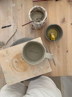 a person is making pottery on a wooden table