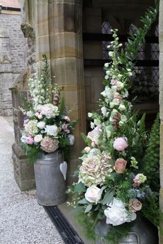 two vases filled with flowers sitting next to each other