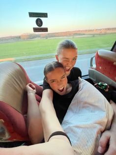 two people sitting in the back of a car with their arms around each other as they laugh