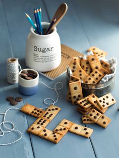 some chocolate chip dominos are on the table next to a cup with pencils