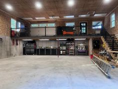 an empty garage is shown with stairs and workbench in the center, as well as several storage cabinets